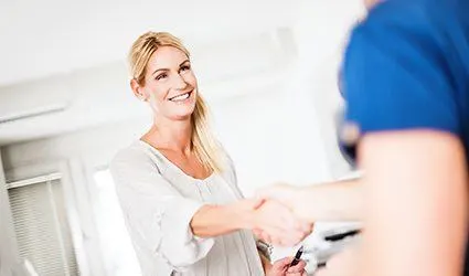Woman shaking hands with dental team member