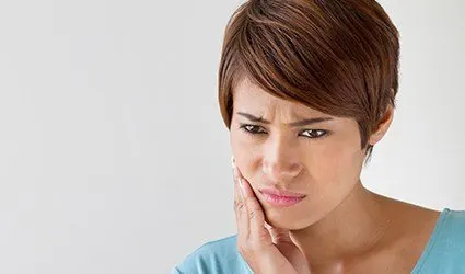 Woman holding jaw in pain