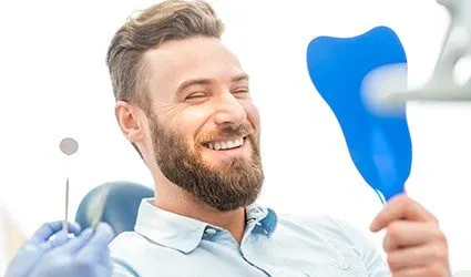 Man looking at smile in mirror