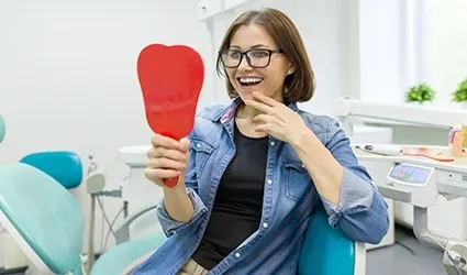 Woman looking at smile in mirror