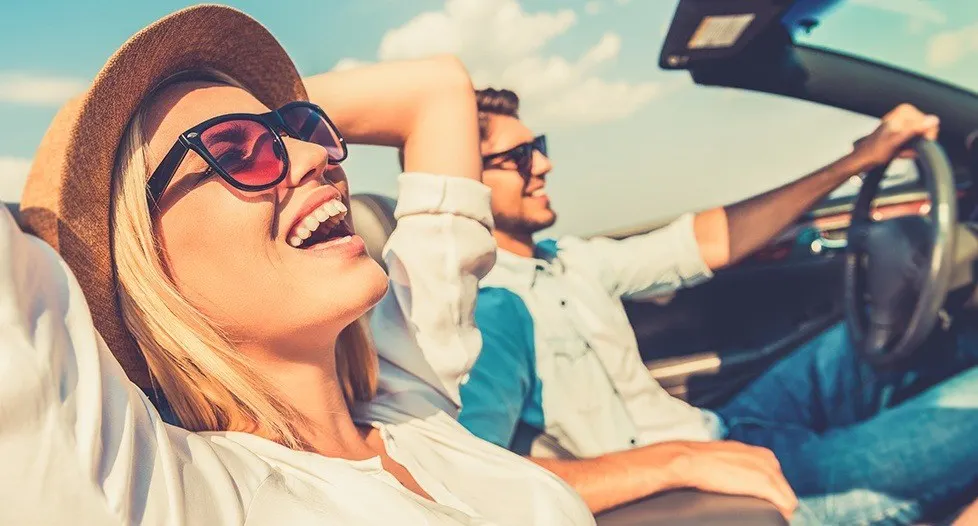 Laughing man and woman in convertible