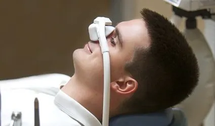 A young man wearing a nitrous oxide nasal mask