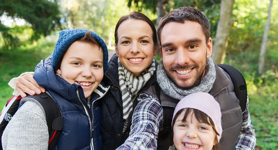 Smiling mother father and two kids outdoors