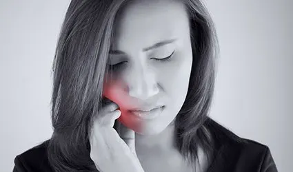 Woman in pain holding cheek