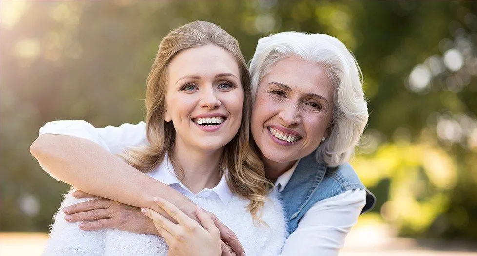 Smiling mother and daughter outdoors