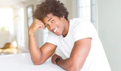 person resting on countertop and smiling