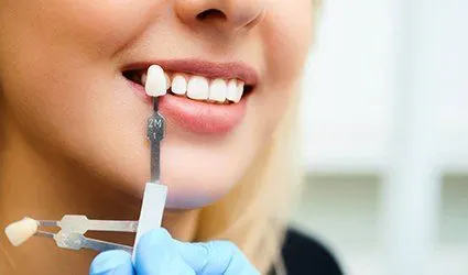 Closeup of smile compared with tooth shade tool