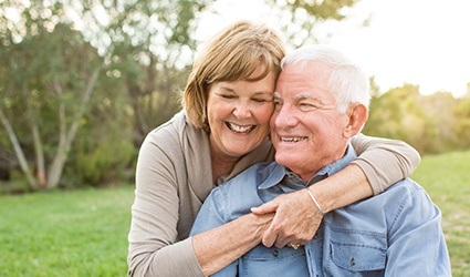Smiling older man and woman outdoors