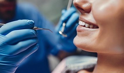Dentist looking at female patient’s teeth