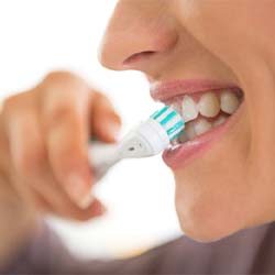 Woman brushing her teeth with electric toothbrush
