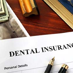Dental insurance paperwork on brown wooden desk
